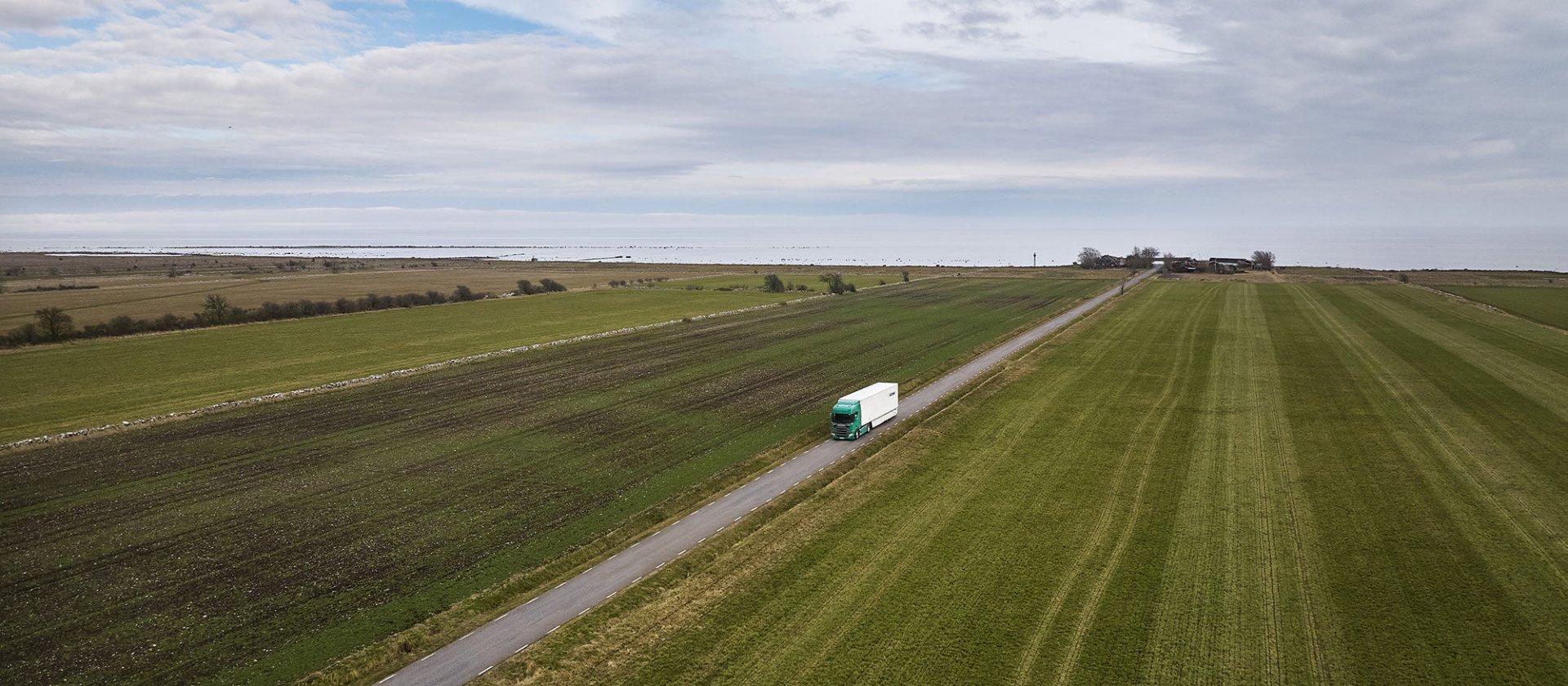Truck on a road with green fields